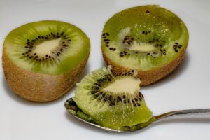 Due kiwi freschi su un tavolo, simbolo di un rimedio naturale contro la stitichezza.
